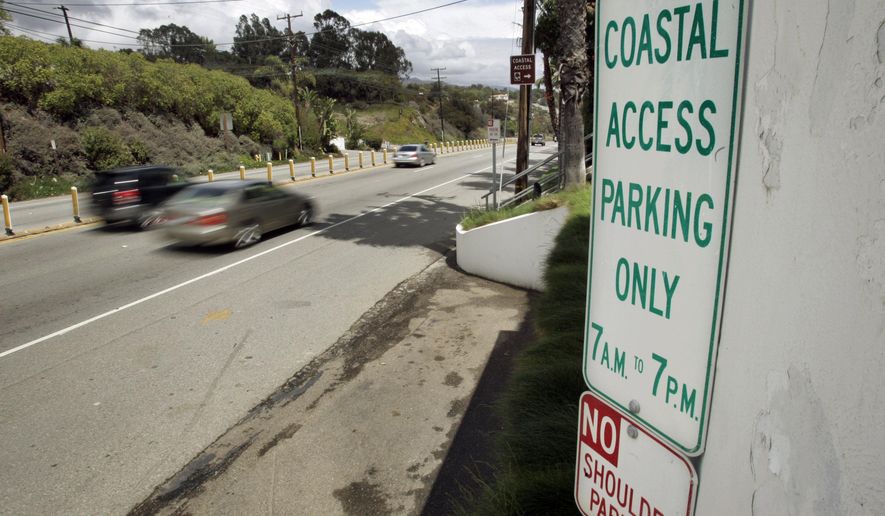 FILE - In this April 20, 2007 file photo a sign directing visitors to two parking spaces next at a coastal access gate for Escondido Beach is shown on Pacific Coast Highway in Malibu, Calif. A new smartphone app that shows users a map of more than 1,500 access points along the California coast was created with help from a tech billionaire whose elaborate wedding ran afoul of state regulators. (AP Photo/Reed Saxon, File)