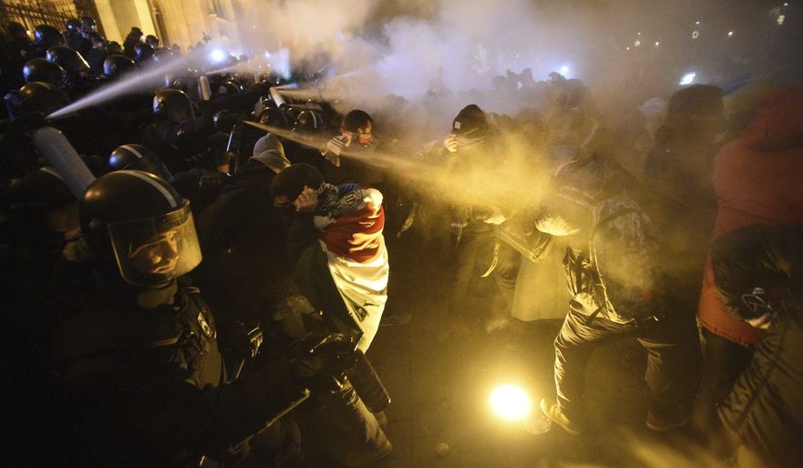 Protesters clash with police during a demonstration against the amendments to the labour code, dubbed &amp;quot;slave law&amp;quot; by oppositional forces, at the parliament building in Budapest, Thursday, Dec. 13, 2018. Thursday&#39;s evening rally was called to oppose recent changes to the labor code which unions and critics say will hurt workers and protesters shouted slogans against Prime Minister Viktor Orban. Some protesters threw bottles and smoke bombs at police in riot gear guarding the neo-Gothic national legislature.(Zoltan Balogh/MTI via AP)