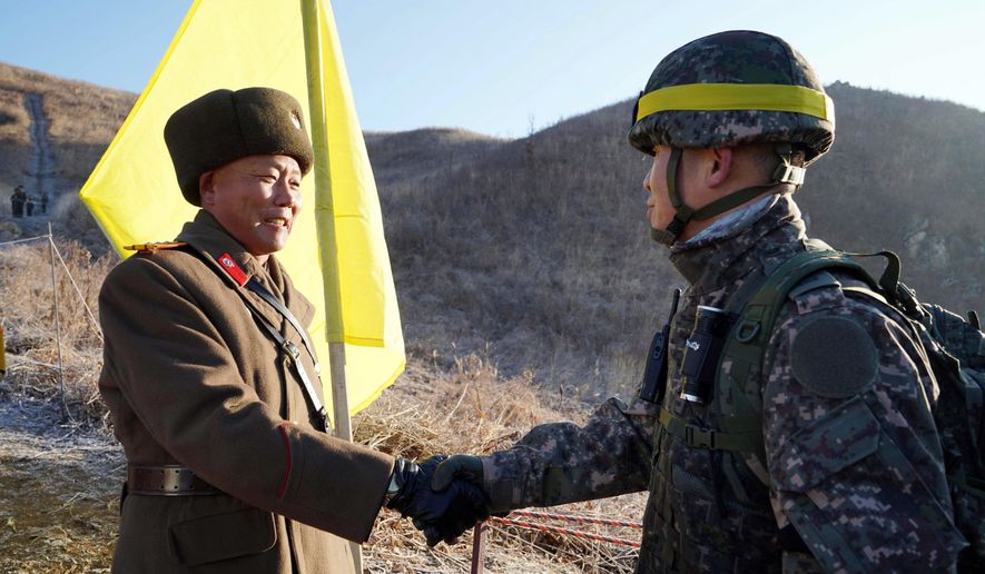 In this Wednesday, Dec. 12, 2018, file photo provided by South Korea Defense Ministry, South Korean army Col. Yun Myung-shick, right, shakes hands with North Korean army Lt. Col. Ri Jong Su before crossing the Military Demarcation Line inside the Demilitarized Zone (DMZ) to inspect the dismantled North Korean guard post in the central section of the inter-Korean border in Cheorwon. Dozens of North and South Korean soldiers crossed over the world's most heavily armed border Wednesday as they inspected the sites of their rival's front-line guard posts to verify they'd been removed, part of inter-Korean engagement efforts that come amid stalled U.S.-North Korea nuclear disarmament talks. (South Korea Defense Ministry via AP, File)