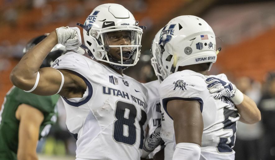 FILE - In this Saturday, Nov. 3, 2018 file photo, Utah State wide receiver Savon Scarver (81) celebrates a touchdown run by his teammate running back Darwin Thompson (5) in the second half of an NCAA college football game against Hawaii in Honolulu. The high-flying offenses of Utah State and North Texas meet in the New Mexico Bowl in what is expected to be a passing attack shootout. Utah State is making its seventh college postseason appearance in eight years while North Texas tries to give head coach Seth Littrell his first bowl victory. (AP Photo/Eugene Tanner, File)