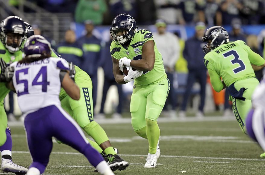 Seattle Seahawks' Rashaad Penny, center, carries against the Minnesota Vikings in the first half of an NFL football game, Monday, Dec. 10, 2018, in Seattle. (AP Photo/Stephen Brashear)