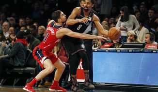 Brooklyn Nets guard Spencer Dinwiddie (8) looks to pass around Washington Wizards guard Tomas Satoransky during the first half of an NBA basketball game Friday, Dec. 14, 2018, in New York. (AP Photo/Adam Hunger)