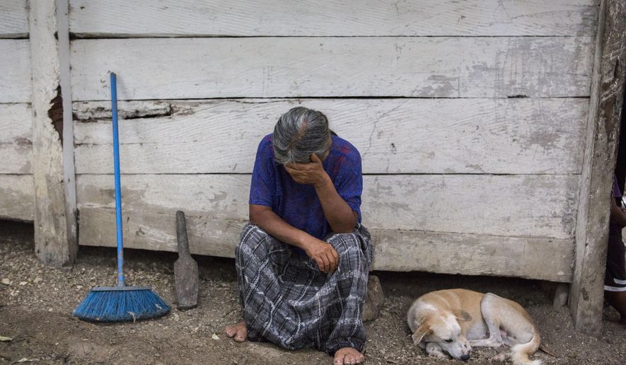 Elvira Choc, 59, Jakelin Amei Rosmery Caal's grandmother, rests her head on her hand in front of her house in Raxruha, Guatemala, on Saturday, Dec. 15, 2018. The 7-year old girl died in a Texas hospital, two days after being taken into custody by border patrol agents in a remote stretch of New Mexico desert. (AP Photo/Oliver de Ros)