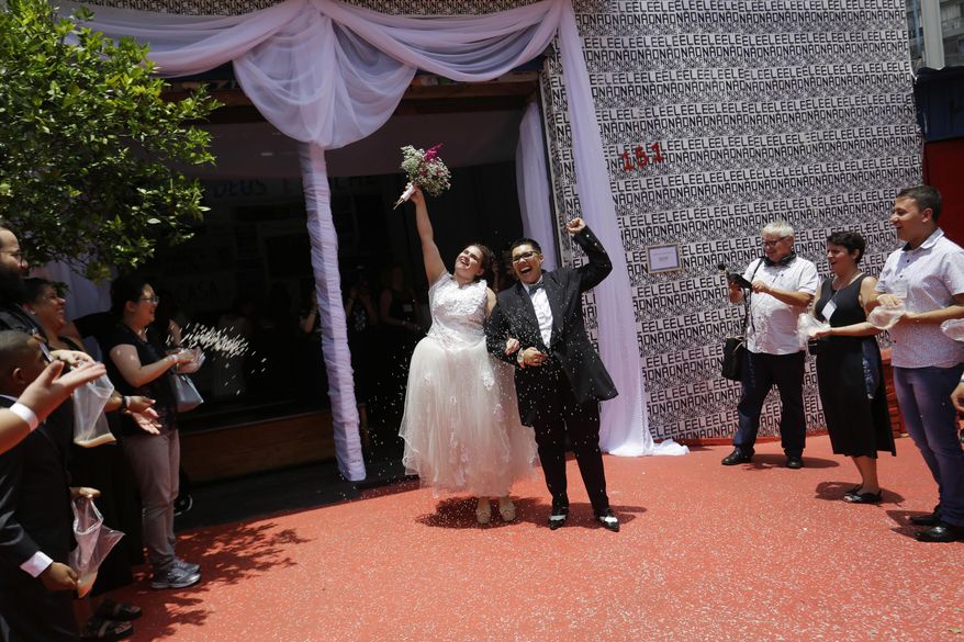 Two women celebrate after getting married in a group marriage of forty same sex couples in Sao Paulo, Brazil, Saturday, Dec. 15, 2018. With the election of ultra-rightist Jair Bolsonaro as president, hundreds of same sex couples began to marry, fearing that the administration of Bolsonaro, who accumulates a history of homophobic and derogatory comments towards gays, could hinder the union of people of the same sex. (AP Photo/Nelson Antoine)