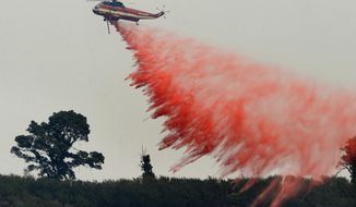 FILE - In this Aug. 13, 2016 file photo, a fire attack helicopter makes a retardant drop during a firing operation on the ridge between Mount Manuel and the Coast Ridge Road while fighting the Soberanes Fire near the village of Big Sur, Calif. The so-called Soberanes Fire burned its way into the record books as the most expensive wildland firefight in U.S. history in what a new report calls &amp;quot;an extreme example of excessive, unaccountable, budget-busting suppression spending that is causing a fiscal crisis in the U.S. Forest Service.&amp;quot; (David Royal/The Monterey County Herald via AP, File)