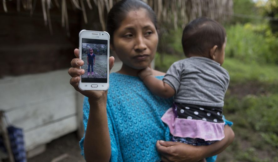 Claudia Maquin, 27, shows a photo of her daughter, Jakelin Amei Rosmery Caal Maquin in Raxruha, Guatemala, on Saturday, Dec. 15, 2018. The 7-year-old girl died in a Texas hospital, two days after being taken into custody by border patrol agents in a remote stretch of New Mexico desert. (AP Photo/Oliver de Ros)