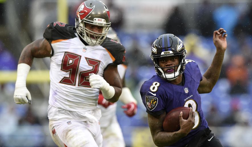 Baltimore Ravens quarterback Lamar Jackson, right, rushes past Tampa Bay Buccaneers defensive tackle William Gholston in the second half of an NFL football game, Sunday, Dec. 16, 2018, in Baltimore. (AP Photo/Gail Burton)