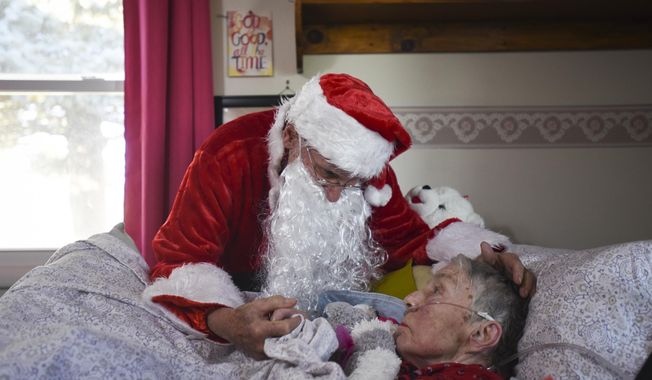 In this Saturday, Dec. 8, 2018 photo, Don West, 90, leans in to kiss his wife Jackie goodnight at Golden Days II Adult Foster Care in Charlotte following a Christmas party for residents and staff at the home.  (Matthew Dae Smith/Lansing State Journal via AP)