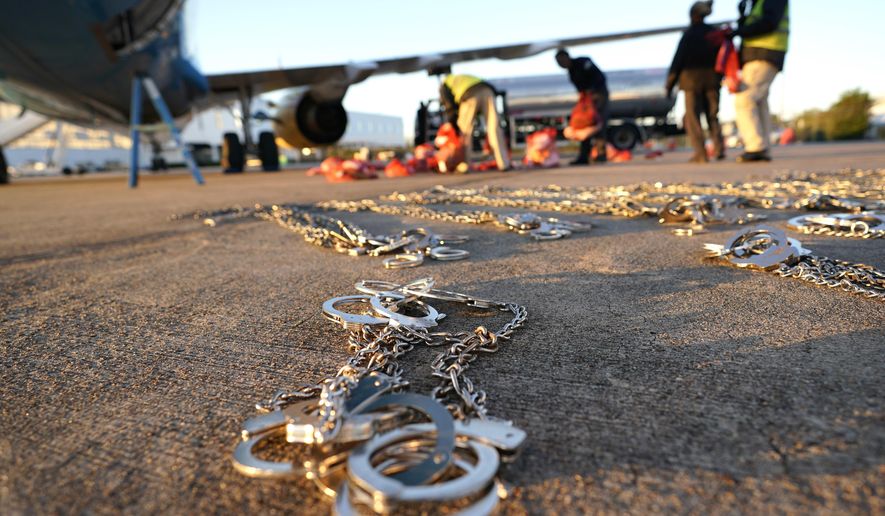 In this Friday, Nov. 16, 2018, photo, restraints lie on the tarmac as personal belongings of immigrants who entered the United States illegally are loaded onto a plane for a deportation flight to El Salvador by U.S. Immigration and Customs Enforcement in Houston. An obscure division of U.S. Immigration and Customs Enforcement operates hundreds of flights each year to remove immigrants. (AP Photo/David J. Phillip) **FILE**
