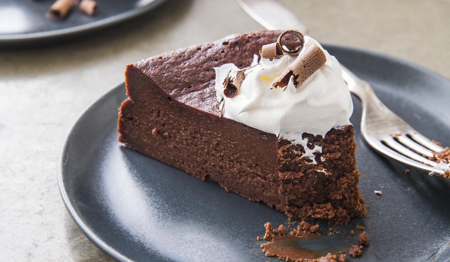 This undated photo provided by America's Test Kitchen in December 2018 shows Flourless Chocolate Cake in Brookline, Mass. This recipe appears in the cookbook "Perfect Cake." (Joe Keller/America's Test Kitchen via AP)