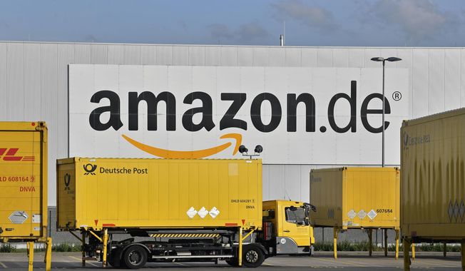 In this file photo dated Wednesday, Nov. 14, 2018, post trucks leave the Amazon Logistic Center in Rheinberg, Germany. Workers at two Amazon distribution centers in Germany have gone on strike as part of a push for improved work conditions, leading to fears that Christmas orders may not arrive in time. (AP Photo/Martin Meissner, file)