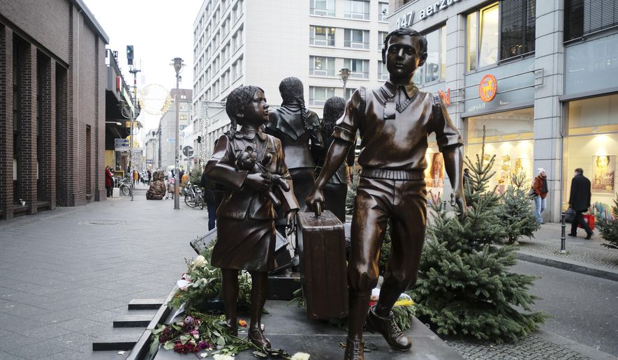 People pass a commemorative memorial statue to perpetuating the memory of the &#x27;Kindertransport&#x27; (children transport) near Friedrichstrasse train station in central in Berlin, Germany, Monday, Dec. 17, 2018. Germany has agreed to one-time payments for survivors, primarily Jews, who were evacuated from Nazi Germany as children, many of whom never saw their parents again. (AP Photo/Markus Schreiber)