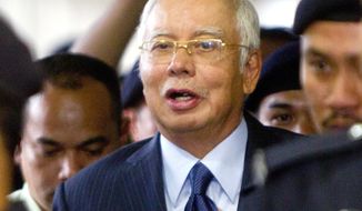 FILE - In this Sept. 20, 2018, file photo, former Malaysian Prime Minister Najib Razak walks out of courtroom after a court hearing at Kuala Lumpur High Court in Kuala Lumpur, Malaysia. Malaysia says it has filed criminal charges against Goldman Sachs and two of its employees in connection with a multibillion-dollar scandal involving state investment fund 1MDB. Najib launched 1MDB in 2009 to promote economic development but it racked up billions of dollars in debts that have led to investigations in the U.S. and several other countries. (AP Photo/Yam G-Jun, FIle)