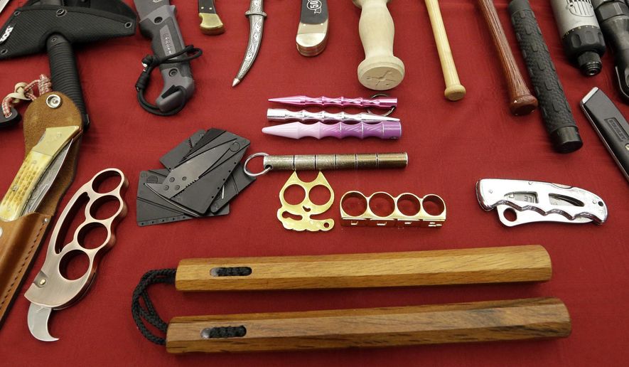 FILE - In this April 6, 2017, file photo, objects confiscated from passengers' carry-on luggage, including nunchucks, bottom, are displayed at Seattle-Tacoma International Airport in SeaTac, Wash. A federal court says New York's ban on nunchucks, the martial arts weapon made famous by Bruce Lee but prohibited in the state for decades, is unconstitutional under the Second Amendment. (AP Photo/Elaine Thompson, File)
