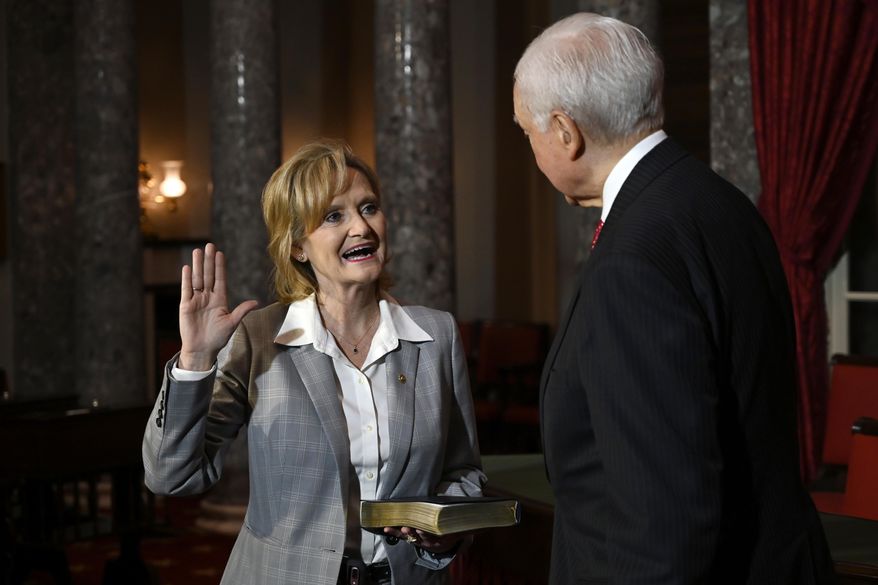 Sen. Cindy Hyde-Smith, R-Miss., left, stands with Sen. Orrin Hatch, R-Utah, right, during a ceremonial swearing-in on Capitol Hill in Washington, Monday, Dec. 17, 2018. (AP Photo/Susan Walsh)