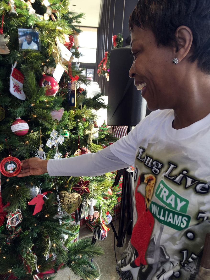 Lisa Donegan of Arlington, Texas, shows an ornament with a photo of her son, 21-year-old Tray Williams, on a Christmas tree honoring Mississippi crime victims, Tuesday, Dec. 18, 2018, in Jackson, Miss. Williams was killed by a hit-and-run driver in 2014 in northern Mississippi’s Pontotoc County. Donegan attended a tree-lighting ceremony where Mississippi Attorney General Jim Hood and Gov. Phil Bryant spoke. (P Photo.Emily Wagster Pettus)