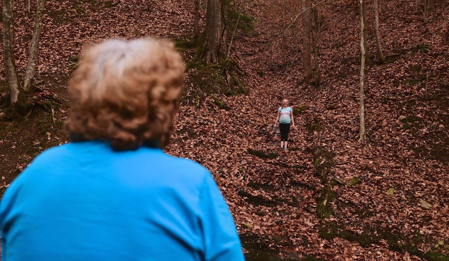 Maggie Hill, 67, watches Charity play in Madison, W.Va., on Thursday, Nov. 29, 2018. Hill adopted the 10-year-old girl about five years ago. Hill's son had been raising her but lost custody during his ongoing struggle with drug addiction, Hill said. (AP Photo/Tyler Evert)