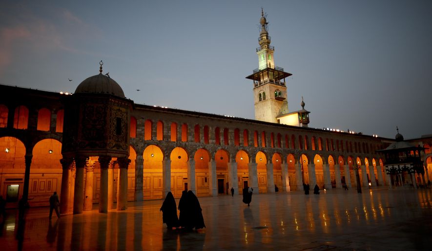 Muslim women walk in the courtyard of the 7th century Umayyad Mosque in Damascus, Syria, Wednesday, Oct. 3, 2018. (AP Photo/Hassan Ammar)