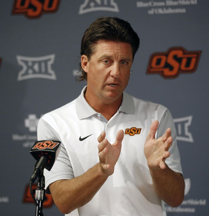 FILE - In this Aug. 24, 2018, file photo, Oklahoma State head coach Mike Gundy talks with the media during an NCAA college football news conference in Stillwater, Okla. College football recruiting fans used to treat the first Wednesday of February like a virtual national holiday. Now that date’s been pushed into the background, likely for good.“I just think everybody sees (December) as the new signing date, in my opinion,” Oklahoma State coach Mike Gundy said. (AP Photo/Sue Ogrocki, File)