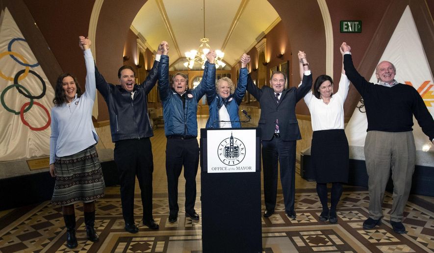 Salt Lake City Council Chairwoman Erin Mendenhall, Fraser Bullock, chief operating officer of the 2002 Winter Games, Jeff Robbins, president and CEO of the Utah Sports Commission, Salt Lake City Mayor Jackie Biskupski, Gov. Gary Herbert, USA Olympic speed skater Catherine Rainey-Norman and Salt Lake County Councilman Jim Bradley raise their arms in celebration after the USOC choose Salt Lake over Denver to bid on behalf of the U.S. for future Winter Games, Friday, Dec. 14, 2018 in Salt Lake City. Salt Lake City got the green light to bid for the Winter Olympics — most likely for 2030 — in an attempt to bring the Games back to the city that hosted in 2002 and provided the backdrop for the U.S. winter team&#x27;s ascendance into an international powerhouse. (Steve Griffin/The Deseret News via AP)