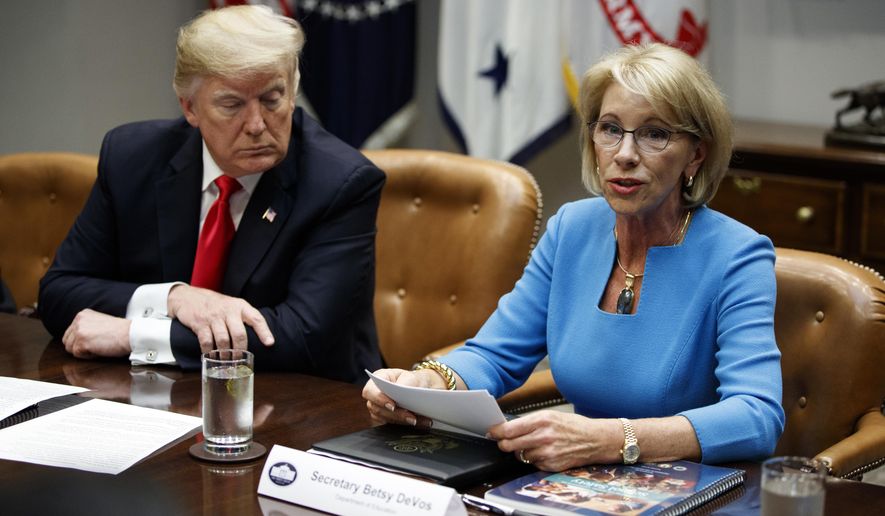 President Donald Trump listens as Secretary of Education Betsy DeVos speaks during a roundtable discussion on the Federal Commission on School Safety report, in the Roosevelt Room of the White House, Tuesday, Dec. 18, 2018, in Washington. (AP Photo/Evan Vucci)