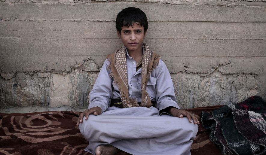 Abdel-Hamid, a 14-year-old former child soldier, poses for a photograph at a camp for displaced persons where he took shelter, in Marib, Yemen, in this July 27, 2018, photo. Tasked by Houthi rebel to carry supplies to other fighters in the high mountains, he says he saw children get shot for not obeying orders. He said the front-lines are full of children. (AP Photo/Nariman El-Mofty)