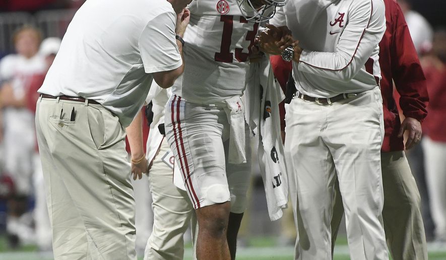 FILE - In this Dec. 1, 2018, file photo, Alabama quarterback Tua Tagovailoa (13) is helped by medical staff during the second half of the Southeastern Conference championship NCAA college football game against Georgia, in Atlanta. Tagovailoa is optimistic that he will be fully recovered from ankle surgery and ready to play in the Orange Bowl. The Alabama quarterback and Heisman Trophy runner-up said his left ankle will be just fine for the College Football Playoff semifinal game with Oklahoma on Dec. 29. “I'll probably be at 100 percent by the time the game comes,” Tagovailoa said Wednesday, Dec. 19, 2018. “That's my prediction. Definitely.” (AP Photo/John Amis, File)