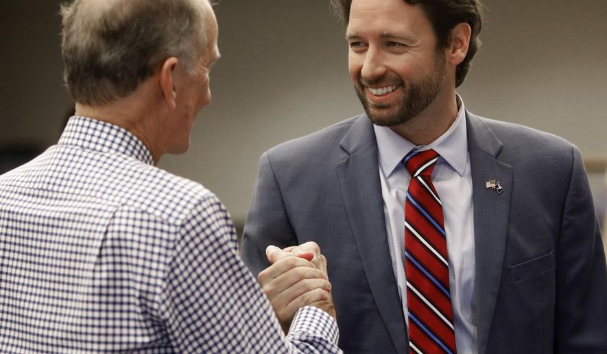 FILE - In this Nov. 7, 2018 file photo, Democratic U.S. House candidate Joe Cunningham, right, shakes hands with Sullivan's Island Mayor Pat O'Neil after Cunningham's victory press conference at the International Longshoremen's Association hall in Charleston, S.C. State GOP Chairman Drew McKissick told The Associated Press on Wednesday, Dec. 19 that he plans to roll out a “victory program” for the 1st Congressional District this spring. Last month, Joe Cunningham narrowly defeated Republican Katie Arrington, becoming the first Democrat to represent South Carolina's 1st District in more than 30 years. McKissick called Cunningham’s win “the biggest disappointment we had on the ballot” in the 2018 elections. Arrington ousted U.S. Rep. Mark Sanford for the Republican nomination in June. (AP Photo/Mic Smith, File)