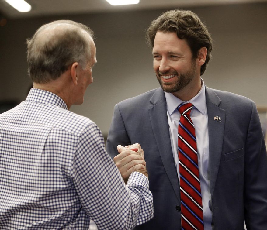FILE - In this Nov. 7, 2018 file photo, Democratic U.S. House candidate Joe Cunningham, right, shakes hands with Sullivan's Island Mayor Pat O'Neil after Cunningham's victory press conference at the International Longshoremen's Association hall in Charleston, S.C. State GOP Chairman Drew McKissick told The Associated Press on Wednesday, Dec. 19 that he plans to roll out a “victory program” for the 1st Congressional District this spring. Last month, Joe Cunningham narrowly defeated Republican Katie Arrington, becoming the first Democrat to represent South Carolina's 1st District in more than 30 years. McKissick called Cunningham’s win “the biggest disappointment we had on the ballot” in the 2018 elections. Arrington ousted U.S. Rep. Mark Sanford for the Republican nomination in June. (AP Photo/Mic Smith, File)