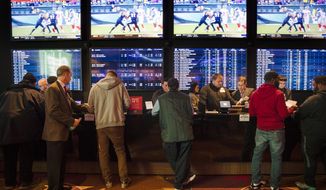 FILE - In this Thursday, Dec. 13, 2018, file photo, gamblers place bets in the temporary sports betting area at the SugarHouse Casino in Philadelphia. The federal government would regulate sports betting nationwide under a bill to be introduced Wednesday, Jan. 19,2018. The bill would have the U.S. Justice Department set minimum standards states must meet in order to offer sports betting, but denies the sports leagues the so-called “integrity fees” they have been seeking in new legislation, essentially a cut of sport betting revenue. (AP Photo/Matt Rourke, File) **FILE**