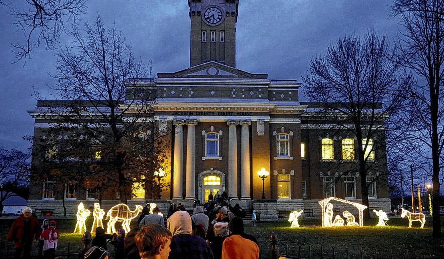 People line down the sidewalk outside the Jackson County Courthouse to see Santa Claus during the Hometown Christmas event Dec. 3 in Brownstown, Ind. An organization that promotes the separation of church and state wants the southern Indiana county to immediately remove a Nativity scene from a courthouse lawn. An attorney for the Madison, Wisconsin-based Freedom From Religion Foundation wrote a letter to commissioners in Jackson County saying that a "concerned local citizen" contacted the group about the light display outside the courthouse in Brownstown. (Jordan Richart/The Tribune via AP)