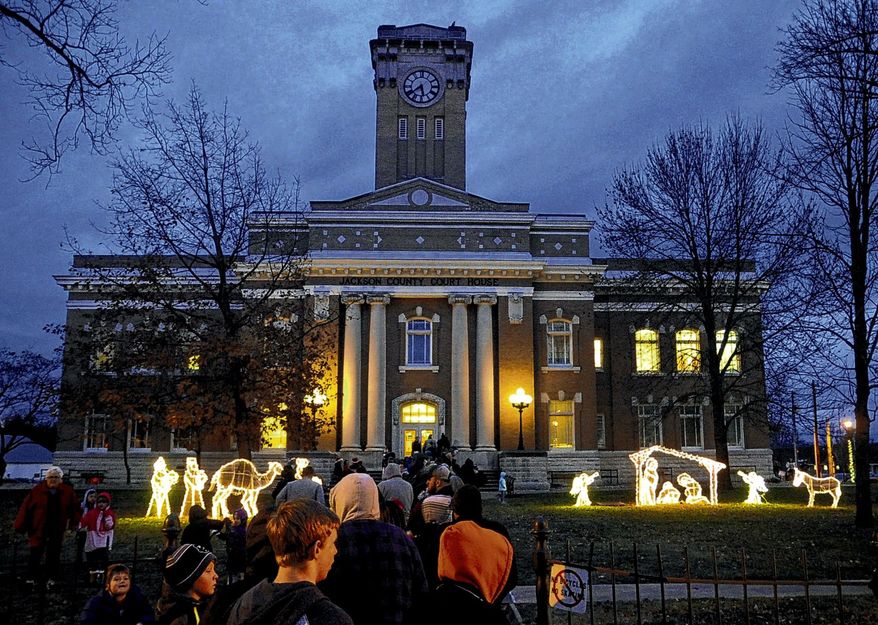 People line down the sidewalk outside the Jackson County Courthouse to see Santa Claus during the Hometown Christmas event Dec. 3 in Brownstown, Ind. An organization that promotes the separation of church and state wants the southern Indiana county to immediately remove a Nativity scene from a courthouse lawn. An attorney for the Madison, Wisconsin-based Freedom From Religion Foundation wrote a letter to commissioners in Jackson County saying that a "concerned local citizen" contacted the group about the light display outside the courthouse in Brownstown. (Jordan Richart/The Tribune via AP)