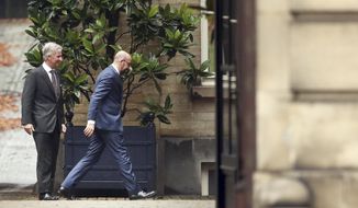 Belgium&#39;s Prime Minister Charles Michel, right, walks away after meeting with Belgium&#39;s King Philippe, left, during consultations at the Royal Palace in Brussels, Friday, Dec. 21, 2018. Prime Minister Charles Michel holds talks with Belgium&#39;s King Philippe as the monarch weighs whether to accept the premier&#39;s resignation and name him at the head of a caretaker government until elections are held in May. (AP Photo/Francisco Seco)