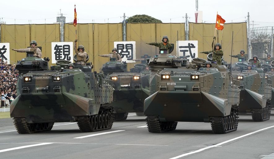 FILE - In this Oct. 14, 2018, file photo, a convoy of assault amphibious vehicles of U.S. Marine Corps, left, and Japan Self-Defense Forces, right, is driven during the Self-Defense Forces Day at Asaka Base in Asaka, north of Tokyo.  Japan&#x27;s Cabinet has approved a record 5.26 trillion yen ($47 billion) defense budget as the country seeks to bolster its arms capability by increasingly buying advanced U.S. weapons. The budget plan endorsed Friday, Dec. 21 rises 1. 3 percent from the previous year, a seventh annual increase since Prime Minister Shinzo Abe took office in 2012.  (AP Photo/Eugene Hoshiko, File)