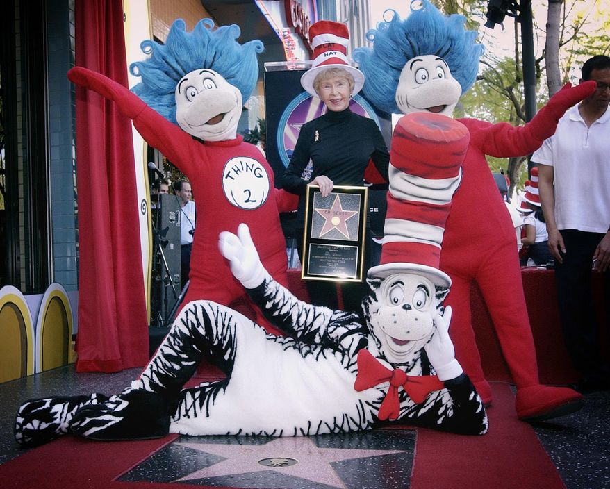 In this March 11, 2004, file photo, Audrey Geisel, widow of famed children's book author Theodor Seuss Geisel, better known as Dr. Seuss, poses with The Cat in the Hat, foreground, and Thing 1 and Thing 2, who are characters from his books, at the dedication of Dr. Seuss' posthumous star on the Hollywood Walk of Fame in Los Angeles. Geisel died peacefully at her La Jolla, Calif., home on Wednesday, Dec. 19, 2018, at age 97. (AP Photo/Reed Saxon, File)