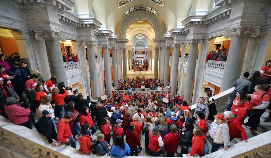 FILE - In this April 2, 2018, file photo, teachers from across Kentucky fill the state Capitol to rally for increased funding and to protest changes to their state funded pension system, in Frankfort, Ky. Thousands of public school teachers converge on Kentucky's Capitol to protest changes to the state pension system made by the Republican-controlled legislature. This one of the top stories in Kentucky in 2018. (AP Photo/Timothy D. Easley, File)