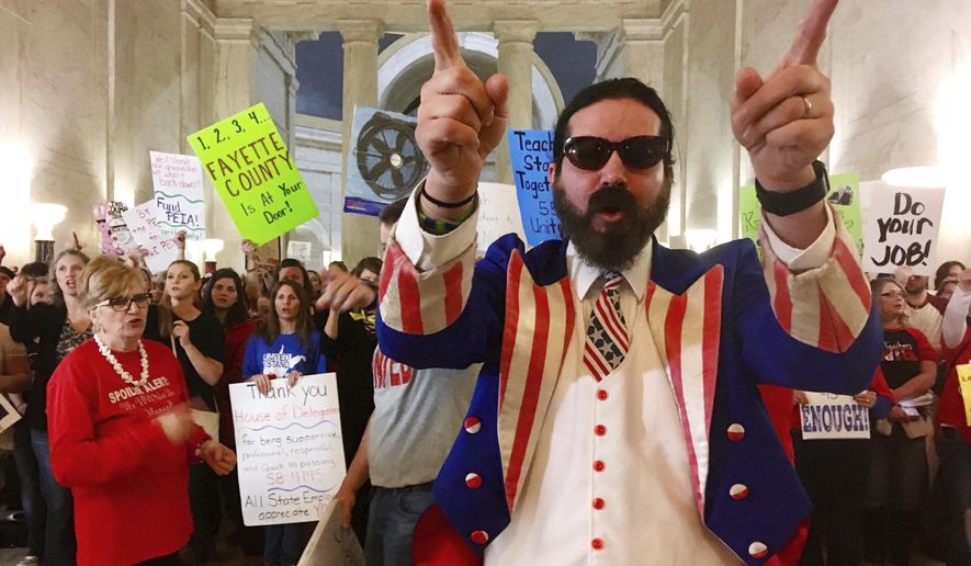 FILE - In this March 1, 2018 file photo, Parry Casto, a fifth grade teacher at the Explorer Academy in Huntington, W.Va., dressed in an Uncle Sam costume leads hundreds of teachers in chants outside the state Senate chambers at the Capitol in Charleston, W.Va This is one of the top stories in West Virginia in 2018. (AP Photo/John Raby, File)