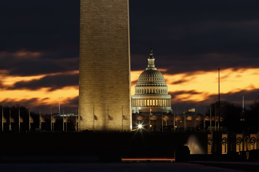 The U.S. Capitol dome is seen past the base of the Washington Monument just before sunrise in Washington, Saturday, Dec. 22, 2018. Hundreds of thousands of federal workers faced a partial government shutdown early Saturday after Democrats refused to meet President Donald Trump's demands for $5 billion to start erecting a border wall with Mexico. (AP Photo/Carolyn Kaster)