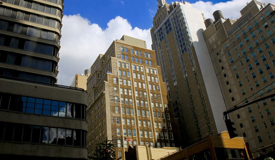 FILE - In this Aug. 1, 2018 file photo, a building once a bustling factory in New York's Garment District, center, is home to the Rag Trader bar and restaurant- which has preserved period artifacts and maintained original wall and flooring in its themed-design. On Thursday, Dec. 20, 2018, the New York City Council approved zoning changes in Manhattan's garment district to allow more space for use by a variety of businesses, while boosting what's left of apparel production in a neighborhood that once clothed much of the country. (AP Photo/Bebeto Matthews, File)