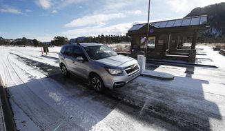 Motorists glide through the unattended toll booths at Rocky Mountain National Park Saturday, Dec. 22, 2018, in Estes Park, Colo. A partial federal shutdown has been put in motion because of gridlock in Congress over funding for President Donald Trump&#39;s  Mexican border wall. The gridlock blocks money for nine of 15 Cabinet-level departments and dozens of agencies including the departments of Homeland Security, Transportation, Interior, Agriculture, State and Justice. (AP Photo/David Zalubowski)