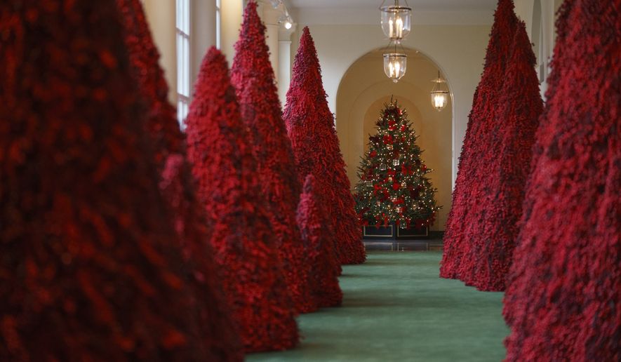 In this Nov. 26, 2018, file photo, topiary trees line the East colonnade during the 2018 Christmas preview at the White House in Washington. Melania Trump&#39;s cranberry topiary trees may have left some of her critics seeing red, but they turned out to be a hit this Christmas _ one of several new wrinkles the Trumps introduced this holiday season. (AP Photo/Carolyn Kaster, File)