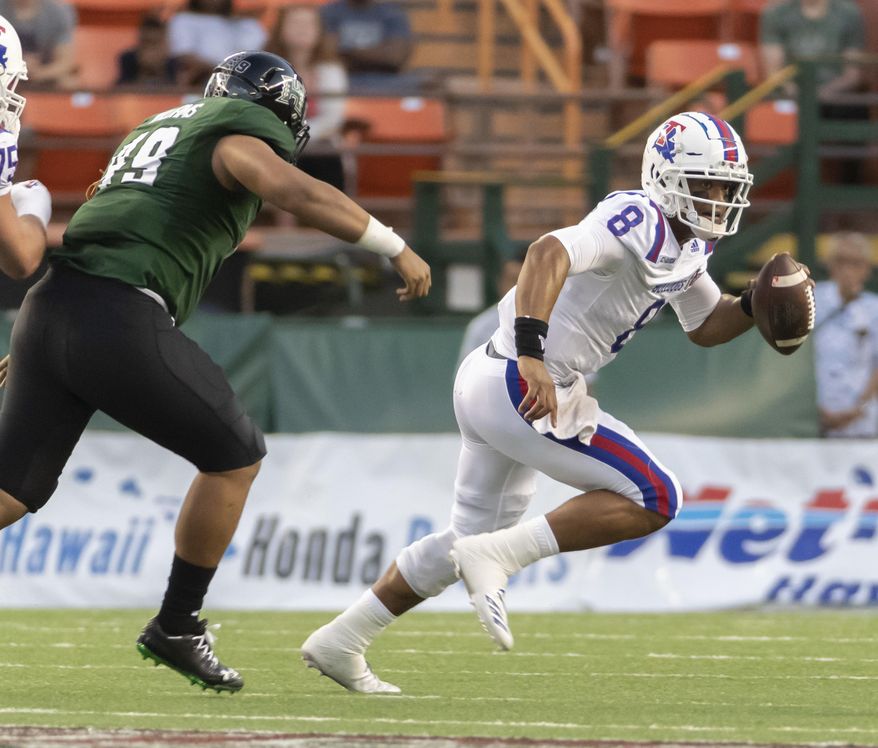 Hawaii defensive lineman Manly Williams (49) attempts to chase down Louisiana Tech quarterback J'Mar Smith (8) in the first half of the Hawaii Bowl NCAA college football game, Saturday, Dec. 22, 2018, in Honolulu. (AP Photo/Eugene Tanner)