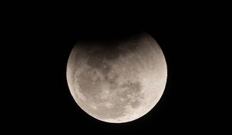 The moon passes into the earth&#39;s shadow during a lunar eclipse as seen in Gauhati, India, Wednesday, Jan. 31, 2018. (AP Photo/Anupam Nath)