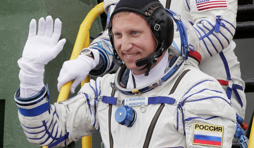 FILE - In this Wednesday, June 6, 2018 file photo, Russian cosmonaut Sergey Prokopyev, crew member of the mission to the International Space Station, ISS, waves as he boards the spaceship prior to the launch at the Russian leased Baikonur cosmodrome, Kazakhstan. Prokopyev, who has explored a mysterious hole in a capsule docked to the International Space Station, says on Monday, Dec. 24 Russia’s law-enforcement agencies are investigating its cause. (AP Photo/Dmitri Lovetsky, Pool)