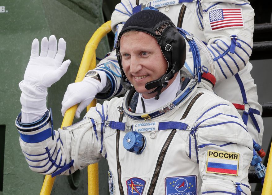 FILE - In this Wednesday, June 6, 2018 file photo, Russian cosmonaut Sergey Prokopyev, crew member of the mission to the International Space Station, ISS, waves as he boards the spaceship prior to the launch at the Russian leased Baikonur cosmodrome, Kazakhstan. Prokopyev, who has explored a mysterious hole in a capsule docked to the International Space Station, says on Monday, Dec. 24 Russia’s law-enforcement agencies are investigating its cause. (AP Photo/Dmitri Lovetsky, Pool)