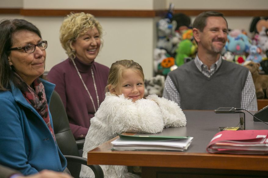 CORRECTS JUDGE'S TITLE TO JEFFERSON COUNTY FAMILY COURT JUDGE DERWIN L. WEBB NOT U.S. DISTRICT JUDGE - Six-year-old Lilly Chitwood, flanked by her new family, reacts happily to Jefferson County Family Court Judge L. Webb who finalized her adoption in Louisville on Thursday, Dec. 6, 2018. (Robin Cornetet/Kentucky Today via AP)