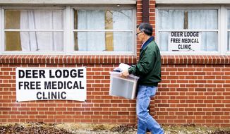 Dr. Tom Kim carries out items before closing down Dr. Kim&#39;s free medical clinic at Abner Ross Memorial Center in Deer Lodge, Tenn., on Friday, Dec. 14, 2018. (Brianna Paciorka/Knoxville News Sentinel via AP)