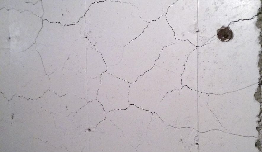 FILE - In this April 11, 2017, file photo, numerous cracks run through a basement wall of a home in Willington, Conn. A new $12 annual surcharge will begin being levied on certain homeowner insurance policies from Jan. 1 until Dec. 31, 2029. Under the law, 85 percent of the revenue generated from the surcharge will be deposited into the Crumbling Foundations Assistance fund to help homeowners with concrete foundations damaged by the presence of pyrrhotite, an iron sulfide that reacts naturally with water and oxygen, causing the concrete to crack and crumble. (AP Photo/Susan Haigh, File)