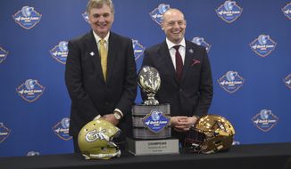 FILE  -  In this Dec. 5, 2018 file photo Georgia Tech head coach Paul Johnson, left, and University of Minnesota head coach P.J. Fleck pose with the NCAA college football Quick Lane Bowl trophy at a news conference in Allen Park, Mich. Johnson will lead Georgia Tech for the final time Wednesday, Dec. 26, 2018 against Minnesota in the Quick Lane Bowl. Johnson is 82-59 at Georgia Tech over 11 seasons and 128-88 overall, including six seasons at Navy. Minnesota has a nation-high 52 percent of its roster filled by freshman. The young became bowl eligible by beating Purdue 41-10 and Wisconsin 37-15 in November. (Max Ortiz/Detroit News via AP)