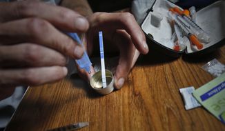 Placing a sensitive fentanyl test strip into a mixing container for heroin can check for contamination, giving the user a choice of whether to take a potentially deadly risk. (Associated Press/File)